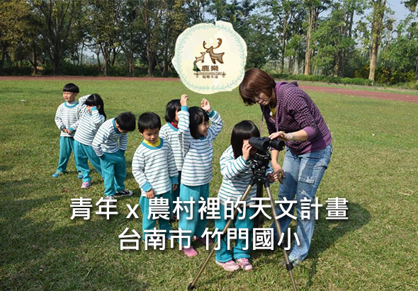 青年與農村裡的天文計畫在台南市竹門國小的活動。一群穿著條紋衣服的學童圍在天文望遠鏡周圍，由一位女性指導員教導觀測。綠色草地上進行戶外天文教育活動，背景為樹木。