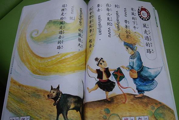 打開的兒童繪本，左頁展示黃色流線與黑色狗隻的插圖，右頁描繪穿著傳統服飾的人物牽著狗奔跑，配有繁體中文及英文文字，講述互動故事情節。