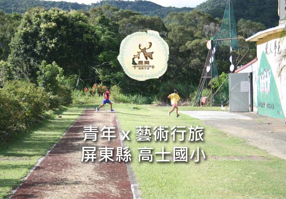 屏東縣高士國小校園，兩位學生在草地跑道上奔跑，展示青年藝術行旅活動。背景為綠色樹林和校舍建築，呈現鄉村學校的自然環境。
