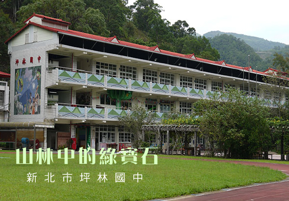 新北市坪林國中校園景觀，一棟紅瓦白牆的三層樓校舍建築，前方有寬闊綠草坪和紅磚步道，背景為青翠山林，校舍牆面有綠色植栽裝飾，展現山中學校的自然環境特色。
