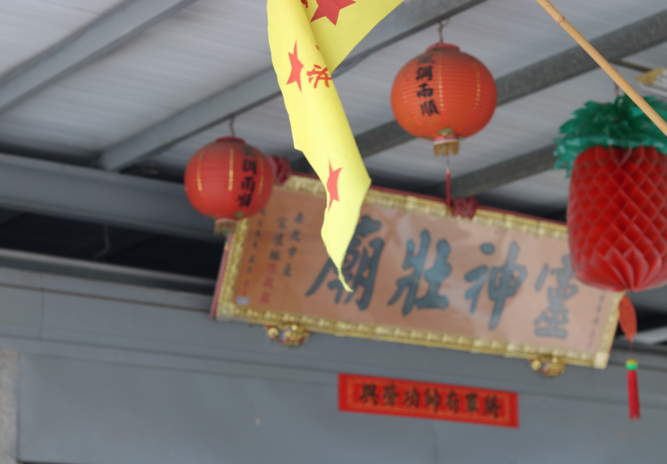 室內天花板懸掛的農曆新年裝飾，包括黃色緞帶、紅色宮燈、木製春聯和紅色剪紙裝飾。整體佈置營造出濃厚的傳統新年氛圍。