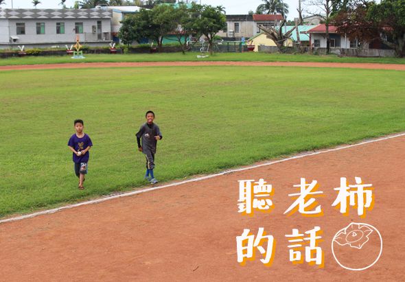 兩名年輕運動員在紅土跑道上奔跑，身後是綠色草坪和校園建築。右下角白色文字寫著「聽老柿的話」，配合卡通表情符號，傳達勵志運動主題。