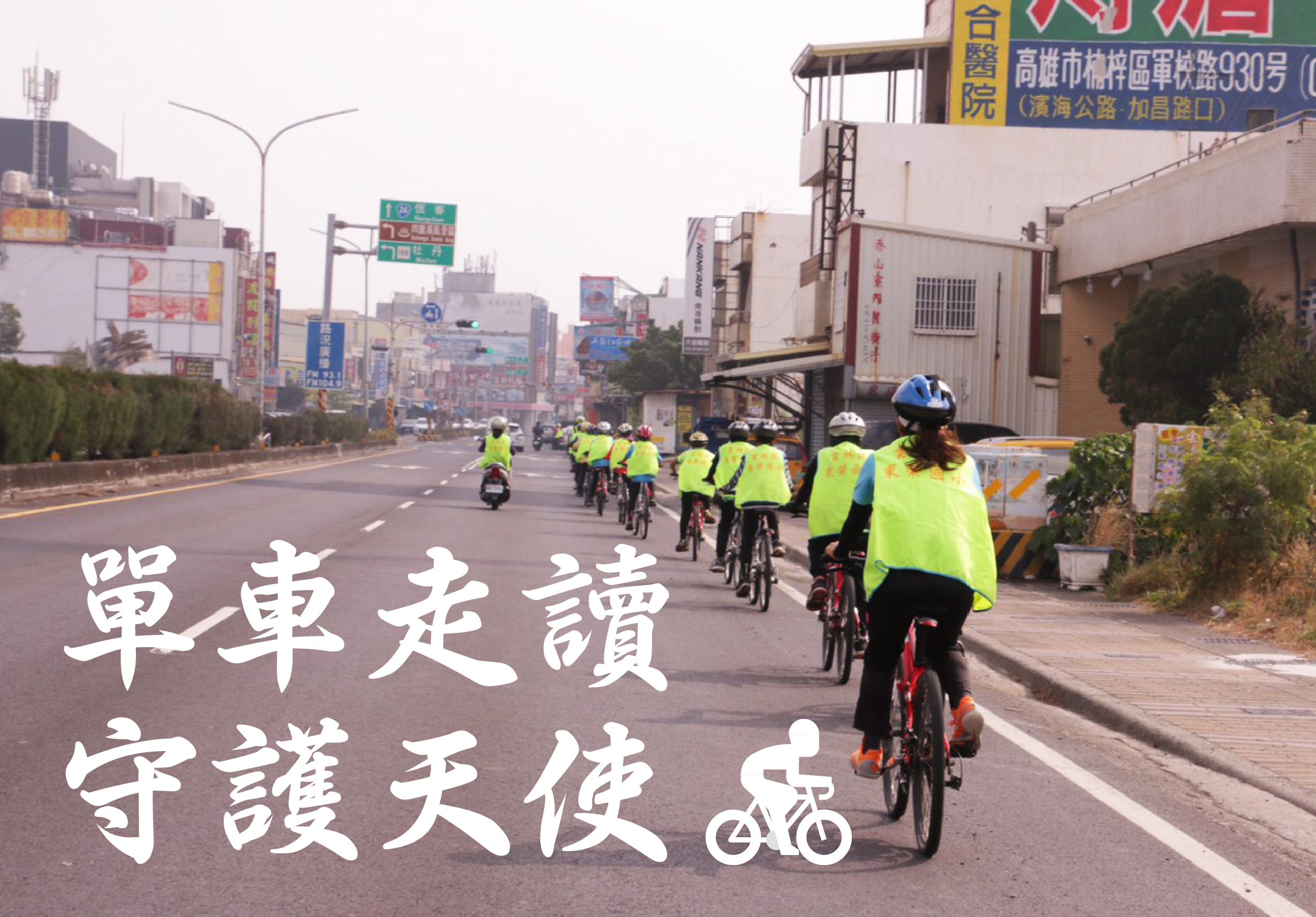 一群穿著螢光黃背心的騎士在寬闊的城市道路上騎自行車，宣傳自行車安全。道路兩側有商業建築和招牌，圖片上方以白色繁體字標示「單車走讀，守護天使」，強調騎自行車的安全重要性。