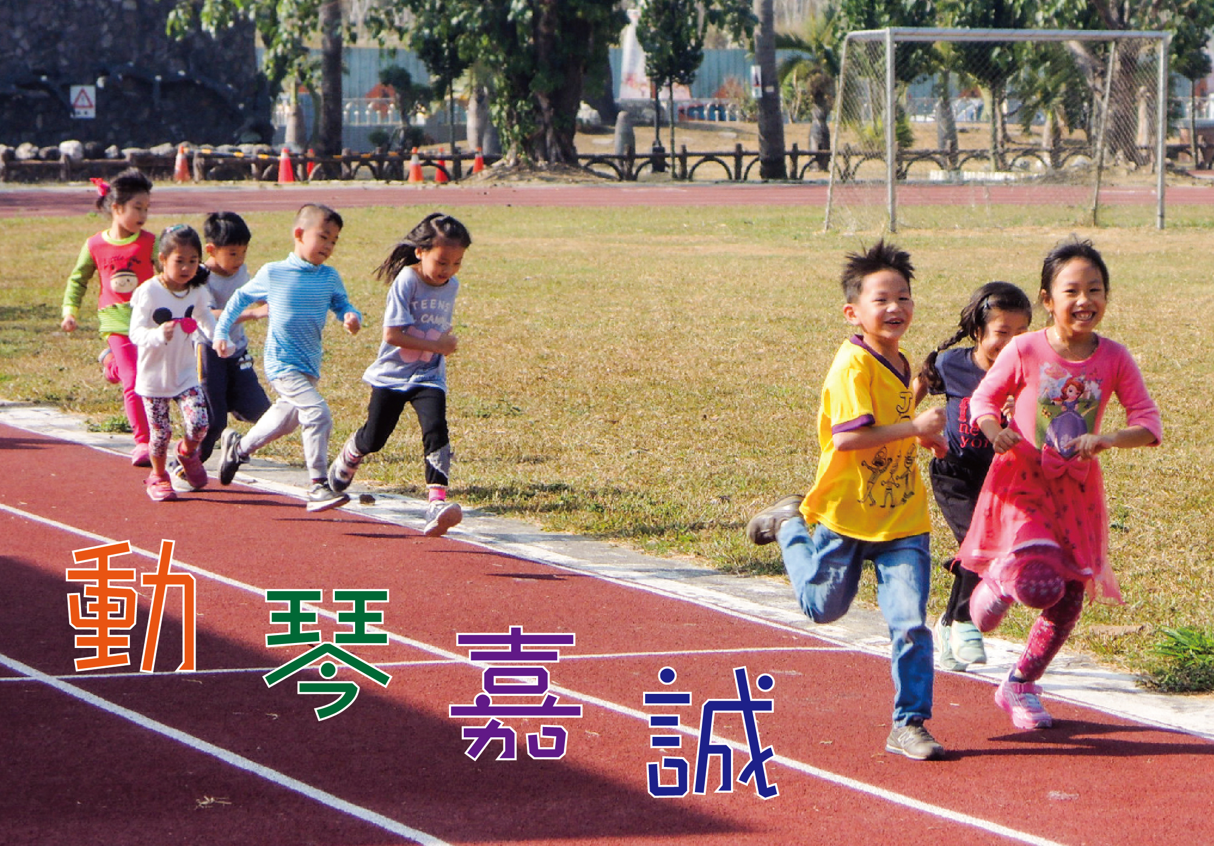 一群兒童在紅色跑道上歡樂奔跑的運動會場景。孩子們穿著五彩繽紛的衣服，展現出活力與笑容。背景為綠色草坪、足球門和樹木。畫面左下角標示橙、綠、紫三色文字「動會嘉賓誌」。