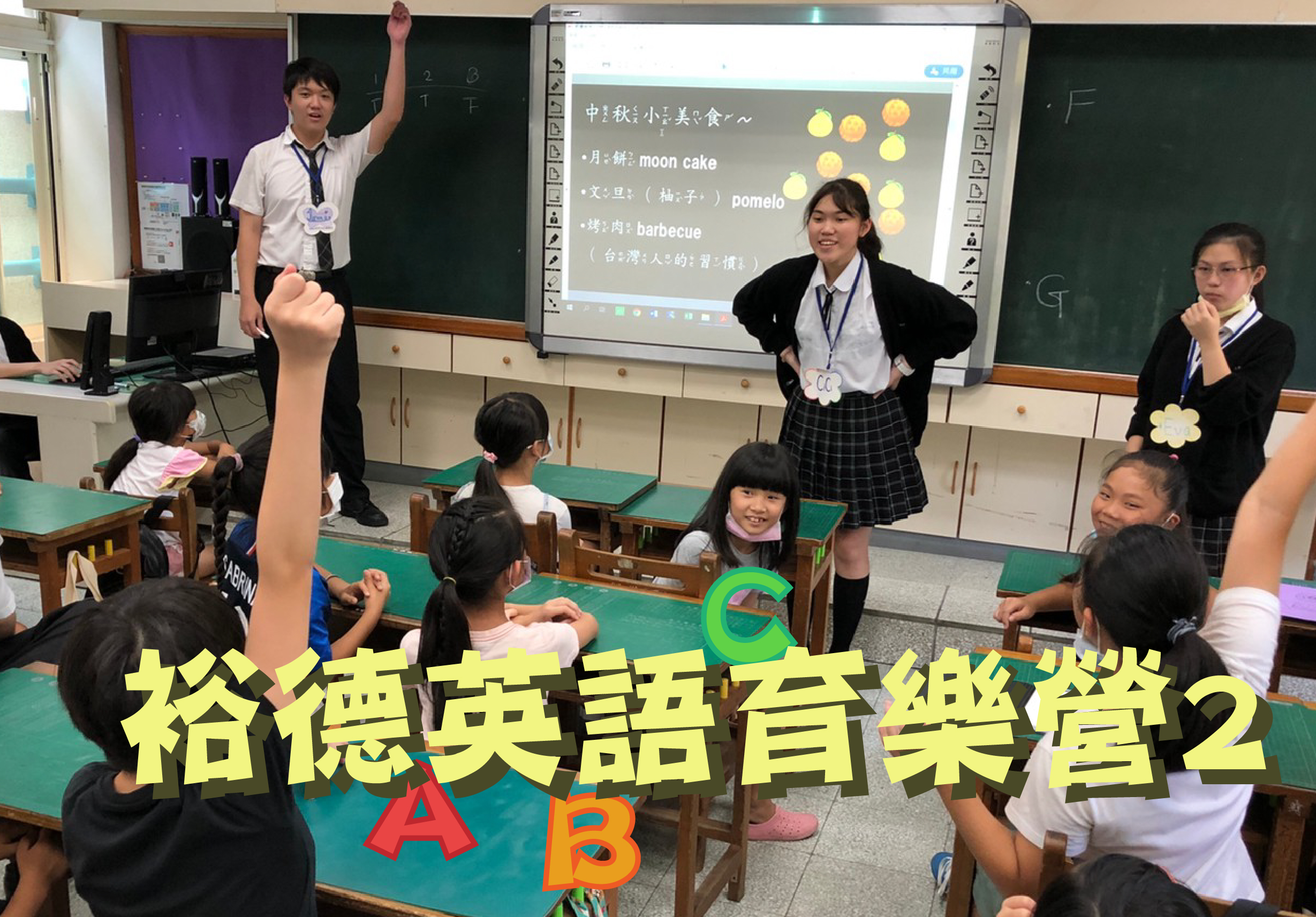 教室內舉辦英語音樂營活動，多位學生圍坐在綠色課桌前，兩名年輕講師站在中央主持。投影螢幕上展示中秋節食物英文教學內容，包含月餅、柚子等詞彙。黃色大字標題寫著「給德英語音樂營2」，現場氣氛活潑歡樂。
