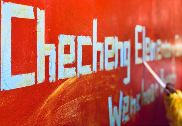 紅色背景的招牌，白色和黃色粗體英文字母拼寫「Chem Lab」，右下角有黃色物體和部分文字可見，呈現化學實驗室或相關教育機構的標識風格。