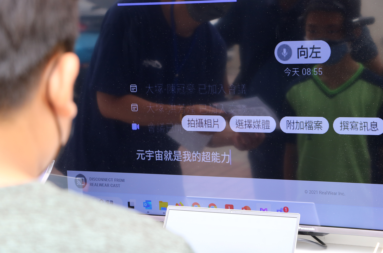電視螢幕顯示繁體中文介面，右上角有「向左」的語音指令標籤，時間顯示08:55。螢幕中央有四個操作按鈕：拍攝相片、選擇媒體、附加檔案、撰寫訊息。下方顯示對話內容「元宇宙就是我的超能力」，左下角顯示RealWear Cast斷線通知。