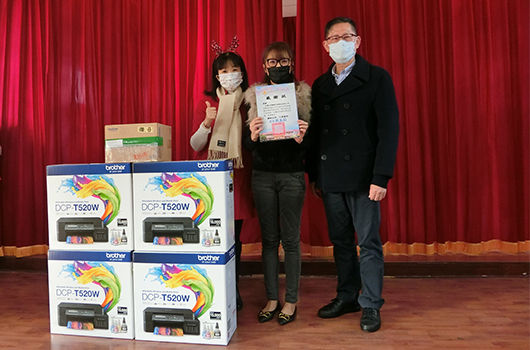 三位獲獎者在紅布幕前合影，展示Brother DCP-T520W印表機四台及獎狀。左起為戴著麋鹿頭飾的女性、中央持獎狀的女性，右側為穿黑色西裝的男性，均佩戴口罩和眼鏡。