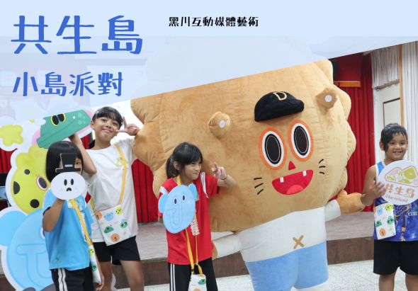 共生島小島派對活動現場，五名兒童與一隻黃色大型卡通吉祥物合照。吉祥物為圓形臉孔，紅色嘴巴，藍色眼睛。兒童穿著彩色背心，手持卡通角色道具。背景為紅色門框和藍色牆面。上方標題「共生島」及「小島派對」，右上角標註「黑川互動媒體藝術」。