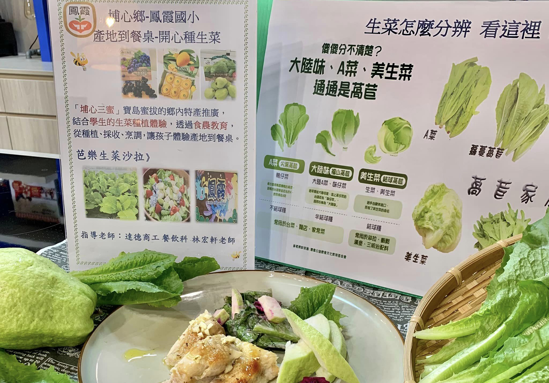 鳳聲國小「博心鄉-鳳聲國小」生菜教學展示。展板介紹如何分辨蘭菜、A菜、美生菜等蔬菜，並展示各類生菜的實物和沙拉料理。桌上擺放新鮮生菜、沙拉盤和教學資料，呈現產地到餐桌的農業教育成果。
