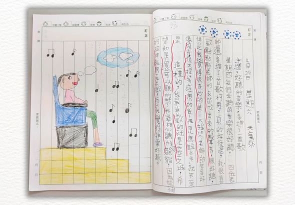 兒童練習本雙頁展開，左頁為彩色插圖，描繪一個坐在黃色方格上的小孩，頭上飄著音符和雲朵；右頁為密集的中文字練習，排列整齊的繁體漢字書寫練習題，用紅筆標注修正。