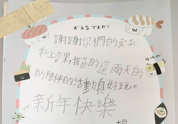 手寫賀狀，內容感謝壽星接納自己，祝福他們生日快樂。頁面邊框裝飾有壽司、飯團等卡通食物角色插圖，色彩繽紛溫暖，表達溫馨的祝賀之意。