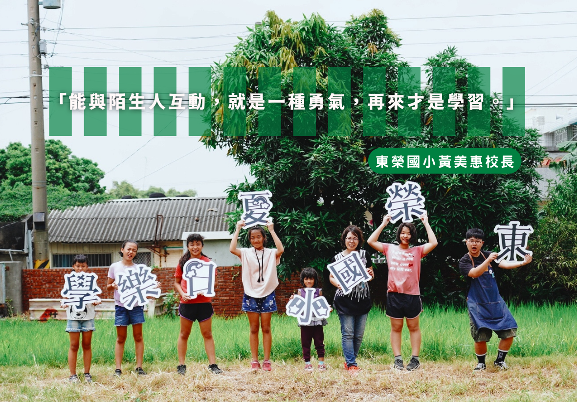 東榮國小學生在校園草地上排成一列，各自舉著白色大字卡牌，組成「學樂國際」四個字。背景為綠色植生牆。上方綠色橫幅寫著校長的勉勵語錄。展示學校國際教育成果。