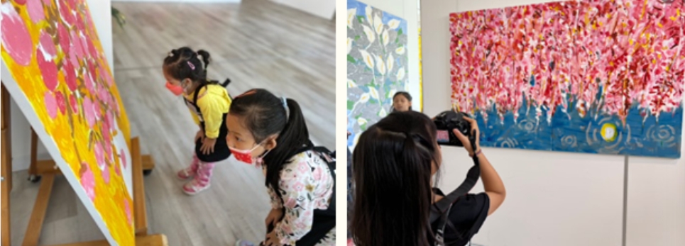 左圖：成人抱著幼兒，在黃粉色漸層的大型藝術作品前駐足觀賞。右圖：訪客在美術館內用手機拍攝粉紅色花卉主題的大型壁畫。展示民眾欣賞和記錄當代藝術展覽的互動情景。