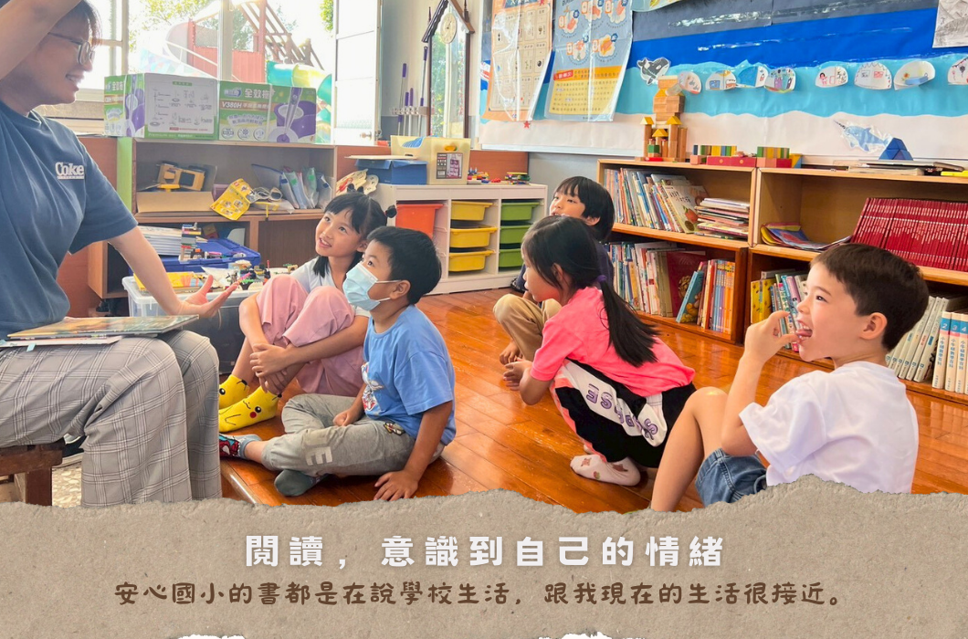 教師在教室裡向五位坐在地上的學童進行閱讀教學活動。教室內有書架、教具和布置。下方文字提示閱讀能幫助認識自己的情緒，安心國小的書都在講學校生活，與現在的生活很接近。