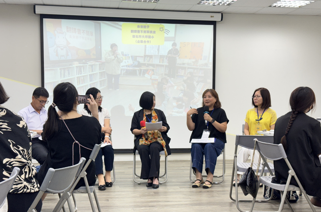 五位講師坐在台上並排交流。一位女性嘉賓持麥克風發言，背景大螢幕顯示與鹿樂平臺合作的專案照片，臺下參與者專注聆聽。