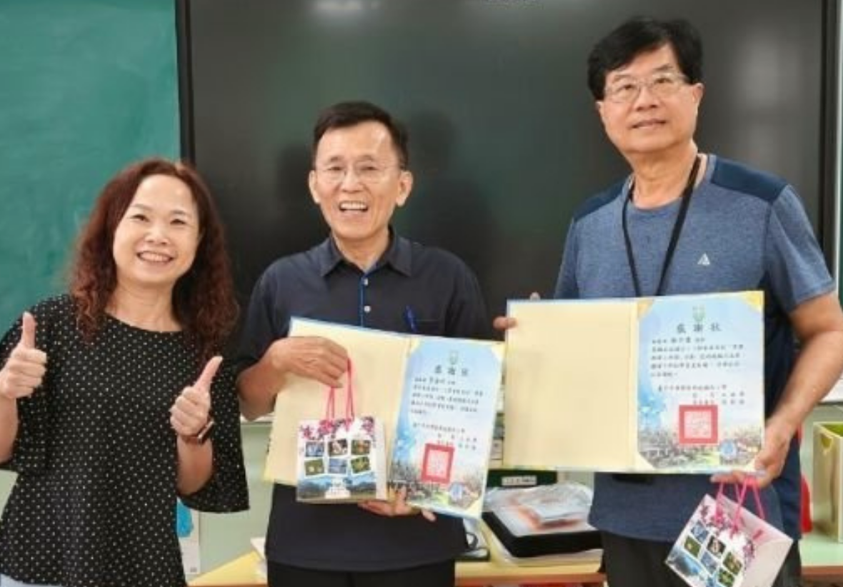 活動頒獎與合影留念。兩位男性講師與一位女性在教室內並排微笑，兩位男性手中各自展示著由主辦單位頒發的活動感謝狀與小禮袋。