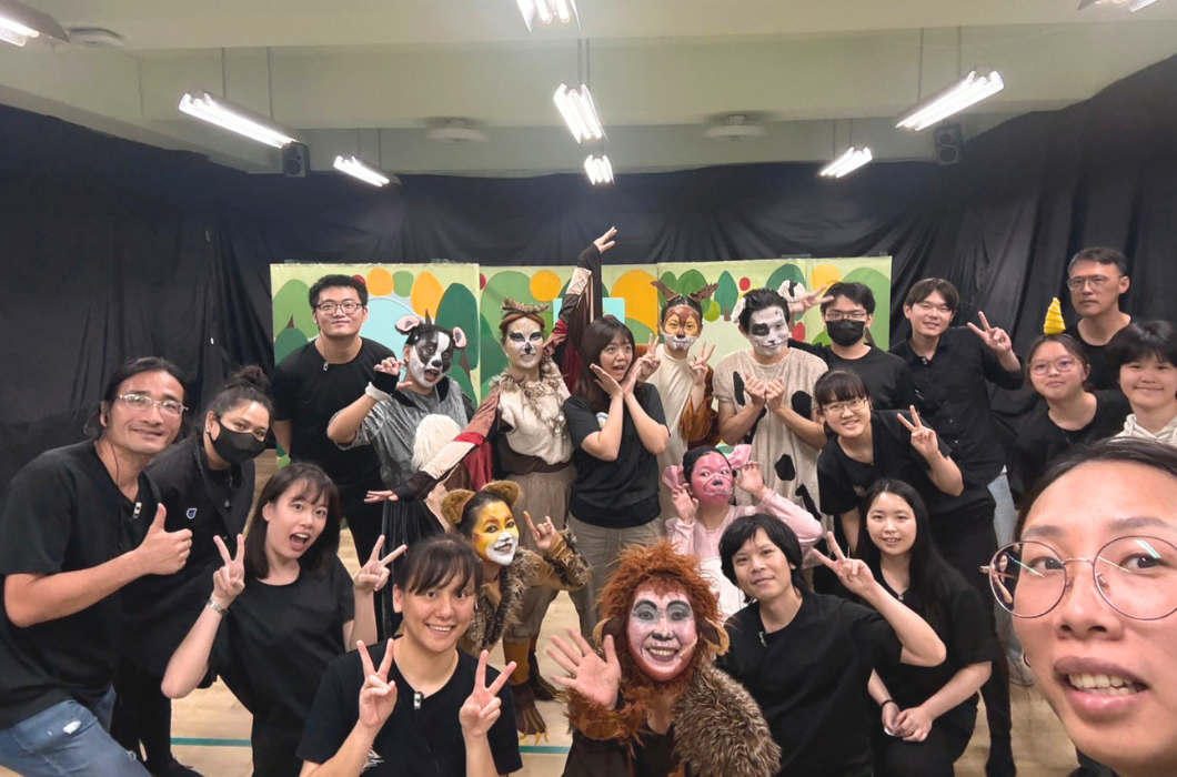 舞台劇演出後的演員與工作人員大合照，部分演員身穿動物裝並畫著動物面部彩繪。
