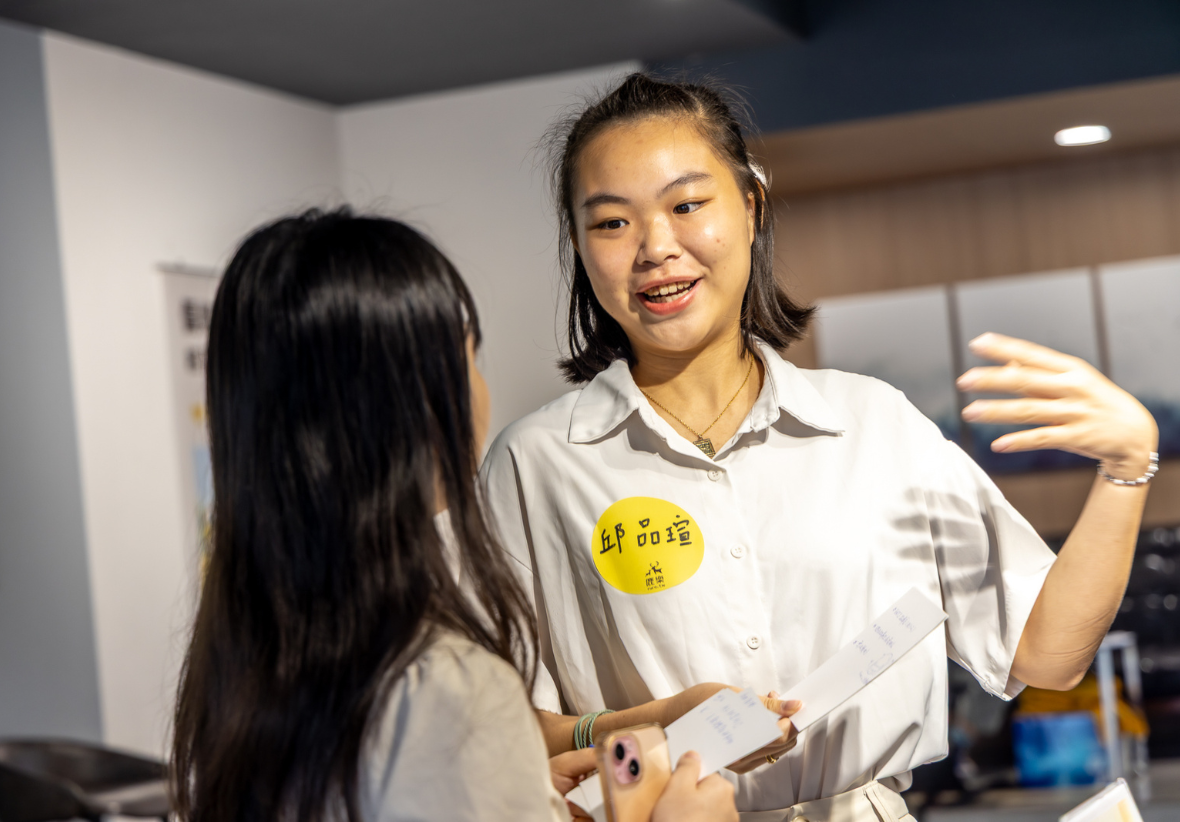 一名女大學，正在與一名長髮女子交談，介紹他自己。