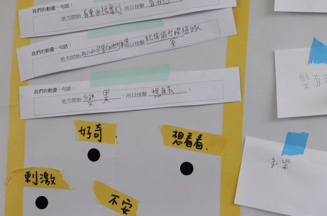 牆面的近拍照，貼有寫著「我們的動畫一句話」的學生成果條與便利貼，便利貼上寫有「好奇」、「不安」、「刺激」等字。