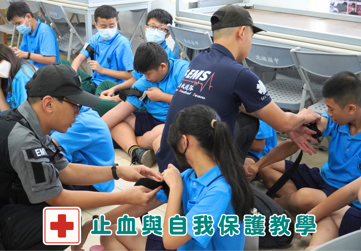 兩名救護人員正在現場指導學生將止血帶綁在手臂上練習，左下角附有「止血與自我保護教學」文字標籤。