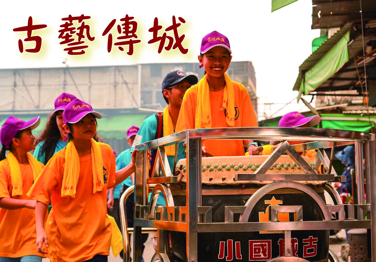 古藝傳城活動現場，穿著橙色上衣和紫色帽子的兒童圍繞著傳統手工藝機器參觀。背景可見綠色棚架和室內場館。圖片展示傳統工藝教育推廣活動。