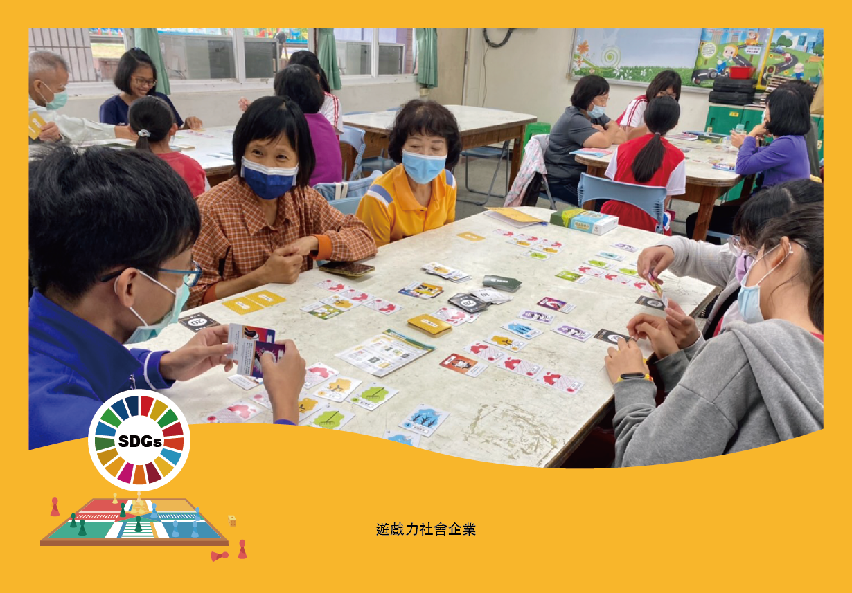 一個教室內，多名學生戴著口罩圍坐在桌邊進行遊戲活動，桌上擺放著各式彩色卡牌和遊戲道具。背景有SDGs永續發展目標標誌，左下方標題寫著「遊戲力社會企業」，呈現寓教於樂的學習情景。