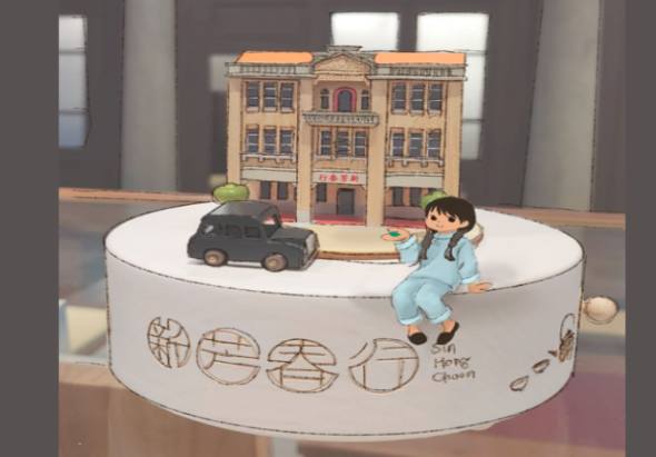 白色圓形展示台上，穿著藍色衣服的女孩坐在玩具車旁，身後有黃色建築模型。台邊緣刻有文字和圖案裝飾，展現互動式美術館或教育展覽場景。